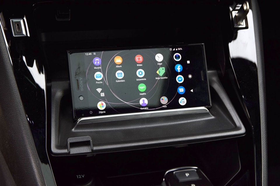 Po opuszczeniu klapki schowka pod panelem przycisków na środkowej konsoli Peugeota na jej wewnętrznej części zauważymy wybrzuszenie, które może być wykorzystane jako stabilna podpórka dla smartfona. Ustawimy go zarówno w pozycji pionowej, jak i poziomej.