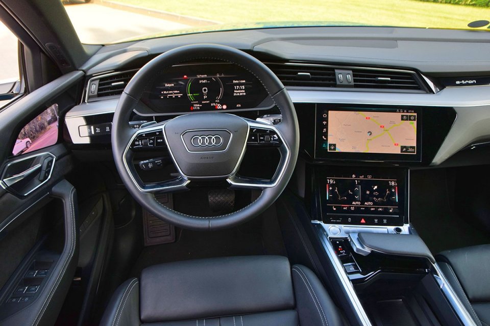 Na desce rozdzielczej znajdziemy wiele rozwiązań znanych z najnowszych modeli, np. Audi A8 i A6. Nowinką są za to nietypowa w kształcie dźwignia zmiany trybów jazdy i wirtualne lusterka. Łopatki pod kierownicą służą do zmiany poziomu rekuperacji.